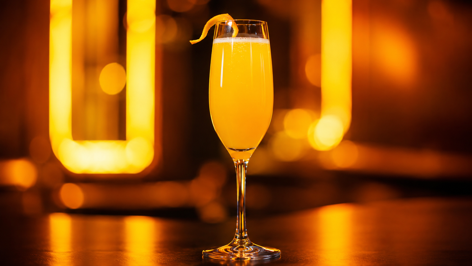 Mimosa vor extrem unscharfem Neonhintergrund in der Farbe des Drinks